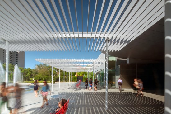 1" x 8" aluminum fins are hung from steel beams creating a porous plane.