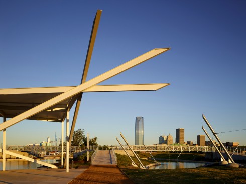 A triangular sun shade balances on carefully nested steel beams.