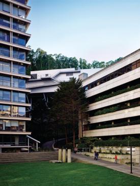 Tucked behind existing buildings, the RMB is accessed via a pedestrian bridge that connects to the ninth floor of a pair of connected 1960s glass-and-concrete structures.