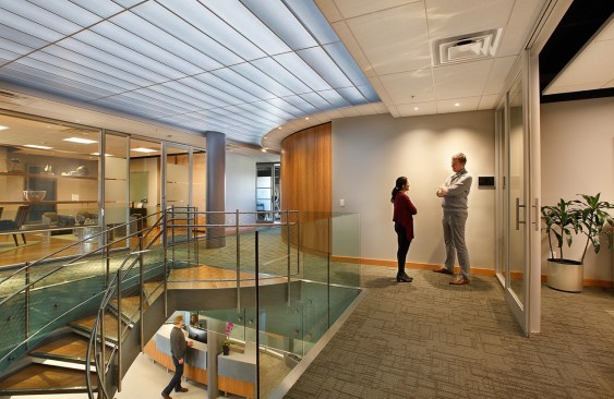 Second floor landing. Wood and glass paneling coupled with a  curved hallway connect the exterior and interior themes.