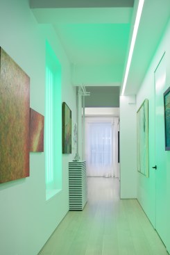 A portal of light in the hallway washes the space in color. 