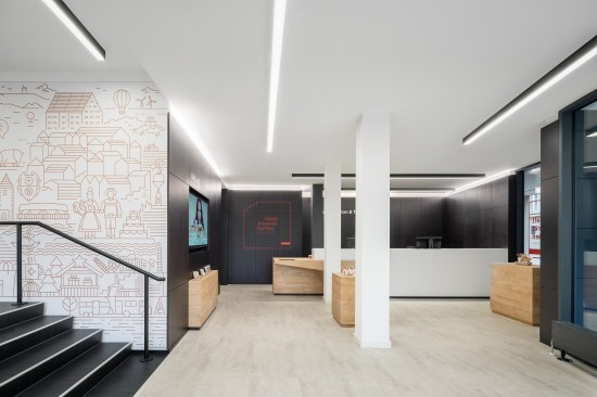 lower retail space with reception desk, digital video screen and presentation space