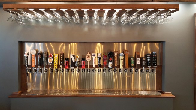 Close up of taps w/ stainless backdrop & floating glass rack