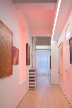A portal of light in the hallway washes the space in color. 