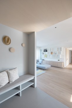 Semi-enclosed foyer designed with comfortable seat, playful hooks and concealed shoes and coat cabinet.