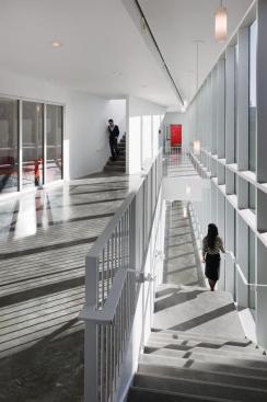 The ramps and switchbacks in the fire-stair volume create not only the building's primary circulation, but also an intentionally choreographed sequence of student and faculty interaction. Separated from the inner volume of the building by fire-rated glass, the projecting volume meets all codes for fire egress, and gives students, who spend the bulk of their time indoors, a chance to connect to the rest of campus.