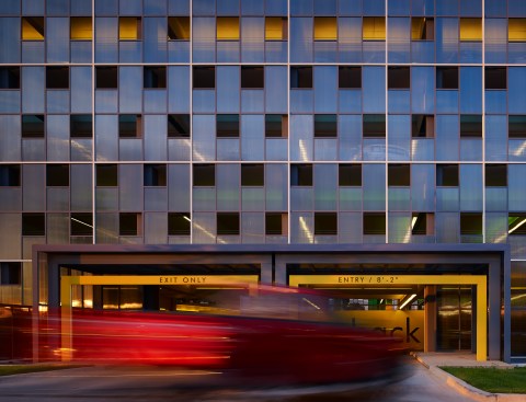The north entry is punctuated by caution yellow headache bars.  The polycarbonate is perforated for air circulation.