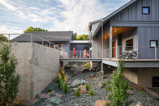 Exterior of new house showing kids on elevated bridge between garage and house