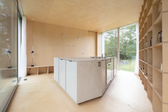 The ground-floor kitchen features a Smeg cooktop and oven set in a cement-board island.