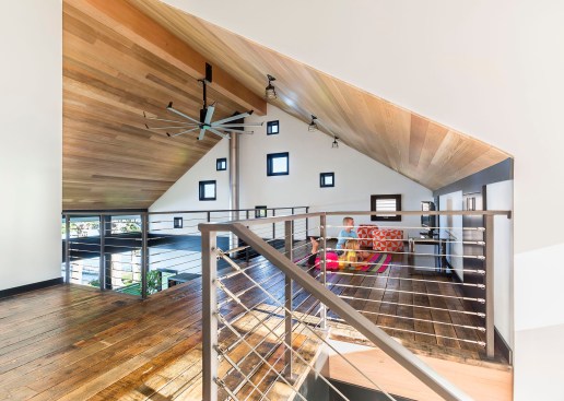 Two children hang out in modern loft space watching television