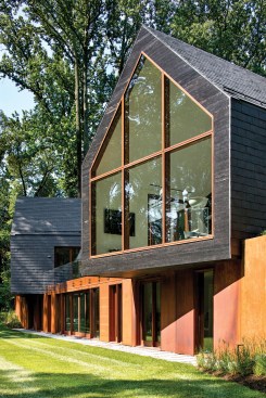 The family room on the main floor juts over the lower level and looks out to the sloped site’s backyard.