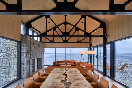 The dining area and great room of the day pavilion are lined in book-matched ash plywood and an aluminum curtainwall with operable vents and doors from Alumicor. 