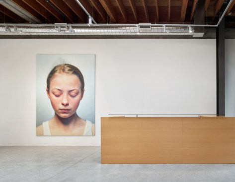 Wood and steel reception desk compliments rawness of existing space.