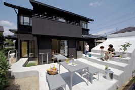 Multitasker The concrete patio boasts and outdoor eating area and bleacher-style seating that marches up the side of a covered garage.
