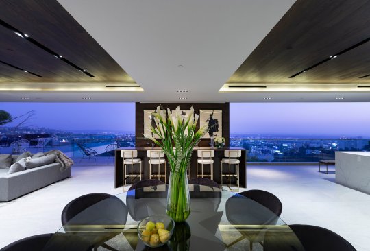 Indoor outdoor kitchen and living room at modern Hollywood Hills resort style home.