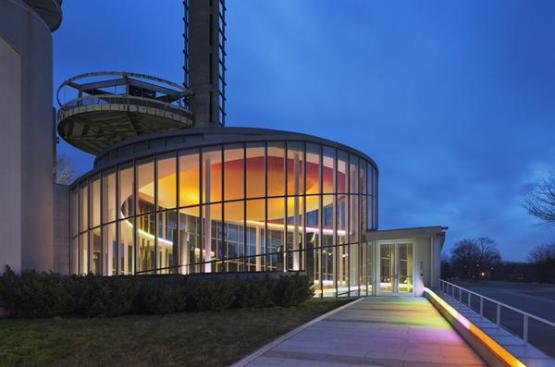 Cold-cathode tubes lead visitors to the building entrances and then continue inside, following the curve of the building's spiraling form.