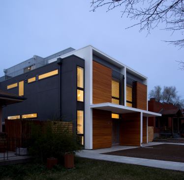 The exterior of the Sustainable Stuart duplex is both contemporary and respective of its older neighborhood context. The third story steps back from the front of the house, giving the impression of a two-story house to tie in with the massing of adjacent houses.