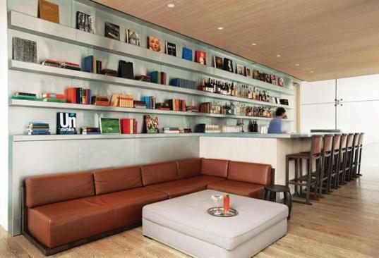 The second floor bar provides a more casual place for guests to linger. Departing from the dark tones of the ground floor spaces, Citterio here turned to lighter woods and a metal paneling system for the walls and built-in bookshelves. Client Klaus Ortlieb, a bibliophile, wanted to include books as part of the d?cor in an effort to create what he calls a ?homey? environment. And books there are?in the lobby library, guest rooms, and even the upstairs bar (shown here).
