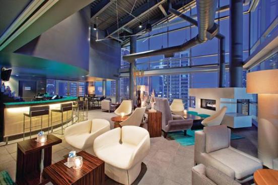 The interior of the rooftop lounge draws a trendy crowd with its open floor plan and high industrial metal ceiling with exposed duct work. Floor-to-ceiling glazing offers an expansive view of the Loop. The lounge?s mod vibe fits in with the hotel?s other boutique attributes, which were a departure for its normally staid parent chain, Doubletree.