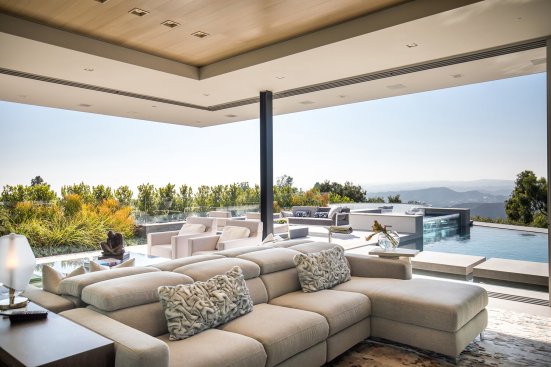 Luxury modern living room with sliding glass walls that open to the pool terrace.