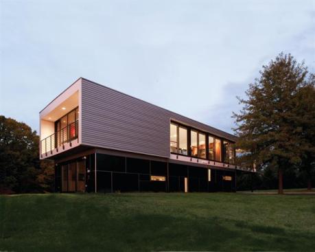 The front facade has metal cladding on the upper portion and dark fiber-cement panels below, so that it appears to hover from a distance. 
