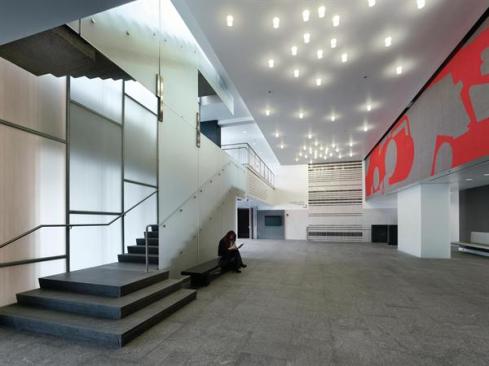 This+lobby+anchors+what+Billie+Tsien+terms+a+%e2%80%9cMain+Street%e2%80%9d+for+the+building%e2%80%94the+path+connecting+the+north+and+south+entrances.+The+translucent+panels+enclosing+the+stair+can+double+as+a+projection+surface.