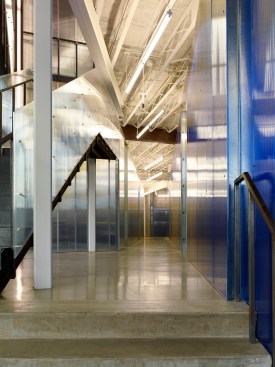 View from the flatiron entry towards the reception desk. The blue polycarbonate office core defines new vs. historic.  The original exposed metal lath and concrete deck above remains.  Floors are polished concrete.  