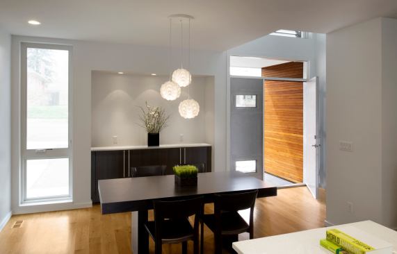 Bright, open rooms reduce lighting needs and strategically placed windows allow for cross ventilation while maintaining privacy on the tight urban lot.