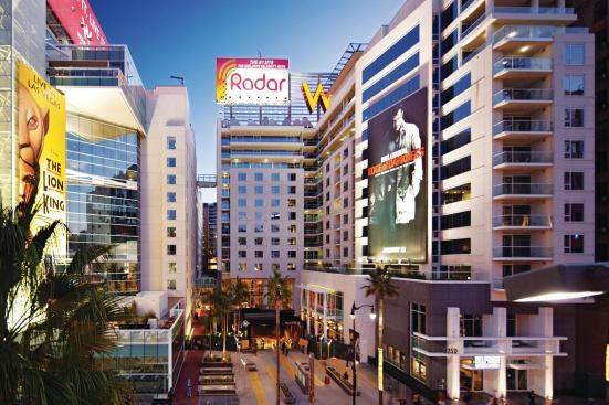 The W Hollywood Hotel & Residences splits guest rooms and residential units into two connected buildings. Billboards, designed by Sussman/Prejza, are attached to a steel structure that stands parallel to the hotel. When illuminated, the super-graphics become a "glowing icon in the night," HKS principal Eddie Abeyta says.