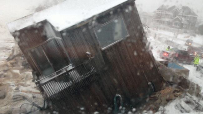 A house slides into the ocean waters at Plum Island, MA, after being hit by pounding waves from Winter Storm Saturn on Friday, March 8, 2013.