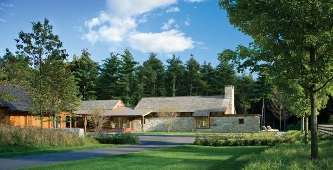 The entry courtyard is sheltered by stone walls, landscaping, and the building itself.