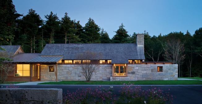 A wall of finely fitted granite masonry lends the north-facing entry elevation a sense of sheltering solidity.