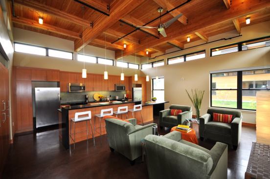 The ceiliing of the shared great room is made of exposed glulam beams with tongue-and-groove decking. The common kitchen contains Energy Star-certified appliances and custom cabinets constructed with FSC-certified fir veneer over non-urea-formaldehyde substrate.