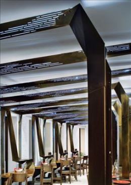 Each beam features a customized pattern of cut-out slots that allow light to shine out from within. The light source is a strip of LEDs, the light from which is bounced off an aluminum reflector to soften the light quality.