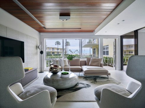 Past the kitchen, the neutral color scheme makes up the living room space with its adjacent floor-to-ceiling windows, harmoniously providing expansive oceanfront views of Fort Lauderdale's captivating beaches.