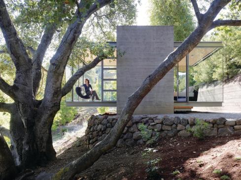 Earthbound concrete towers let the transparent boxes perch delicately above the site.