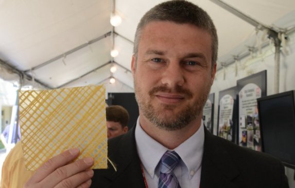 U.S. Army Corps' research mechanical engineer Nick Boone with a piece of the ballistic wallpaper.