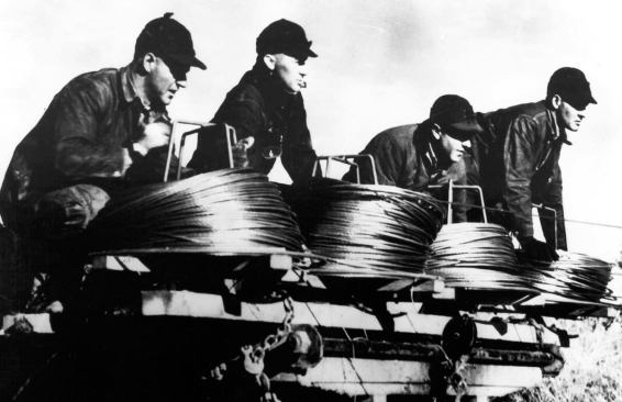 It cost $5 to hook into a local co-op. Trading their labor for the $5 fee are the farmers shown in the photos, pulling the last miles of wire in Horton, Kan., in 1938.