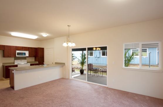 Natural ventilation was a cost-saving strategy. An open plan optimizes the whole-house fan. Living room and bedrooms have at least two walls with windows at body height, and an 8-foot sliding-glass door makes carport dining a breeze.