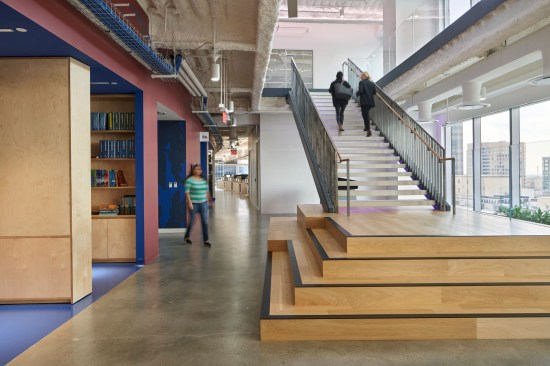 The floating staircase with customizable, colored LED lighting under each step fills this open space and directs employees into private work areas