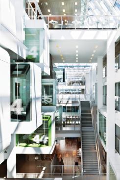 The 10-story atrium at One Shelley Street is the hub for the Sydney branch of Macquarie Bank. The ground level entry area features a warm recycled gum-tree hardwood floor, which serves as a counterpoint to the brightly colored finishes and stark white structure. A series of pods—programmed for meeting rooms, breakout spaces, and eating areas—cantilever out into the void, which is topped by a canted skylight that brings in natural light. Employees move around the space via staircases and bridges that offer circulation alternatives to elevators. "It's had a great impact on [elevator] usage," says Wilkinson, who notes that "they are operating at well below capacity."