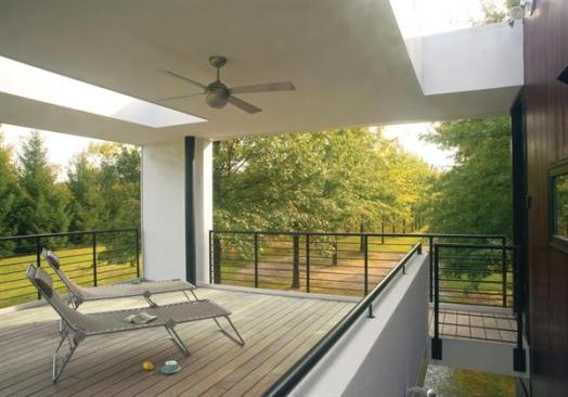 The elevated living area flows out to a porch straddling the allee and driveway. 