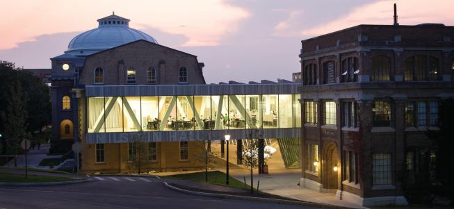 The addition lights up the architecture school at night.