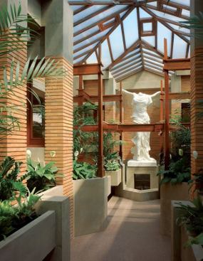 Wright designed the conservatory--much to Mrs. Darwin's chagrin--not as a place to sit and spend a quiet afternoon, but as the terminus of a visual axis from the main house, along the pergola, and to the stature of Nike (now a replacement from the original manufacturer). A window crank system was salvaged from a period greenhouse slated for demolition and installed to manage opening several windows at once for cross ventilation.