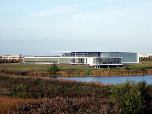 A two-story volume on the east side of the building houses R&D facilities as well as a large public showroom. Channel glass continues the vocabulary of glass bordered by concrete, while obscuring the more industrial space within.
