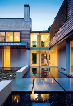 A glass-walled gap marks the point where the two perpendicular pieces of the house come together.
