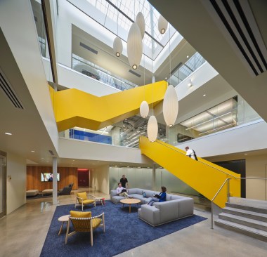 A newly established atrium cuts through the existing building, instituting simplified connections between floors and allowing natural light to filter into subterranean rooms.