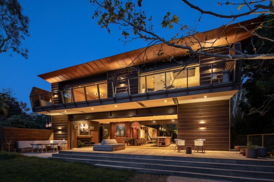 At night the rear of the home, perched on the edge of the canyon, glows through the canopy of trees, giving the effortless impression that it has always been there.