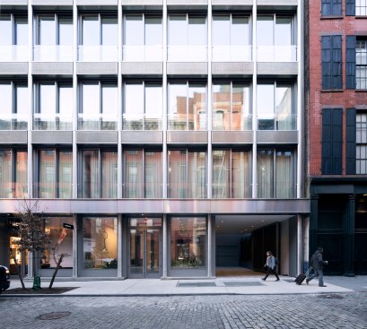 Depth is created on the façade through a layering of materials including stainless steel, brushed aluminum, and metal mesh.