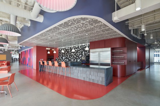 The signature curved ceiling and dotted air vents continue throughout Arup’s office, stopping at the corner of this dynamic kitchen area that invites employees to sit and enjoy the large community space